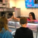Degrandchamps employee handing a family ice cream at the ice cream counter