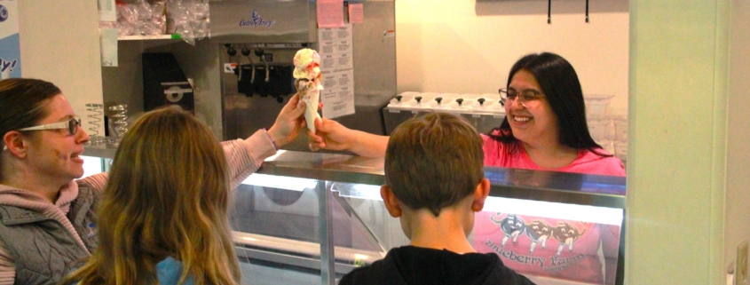 Degrandchamps employee handing a family ice cream at the ice cream counter