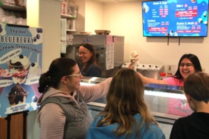 Worker handing a customer their ice cream cone