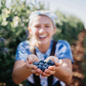 Woman holding blueberries up to the camera